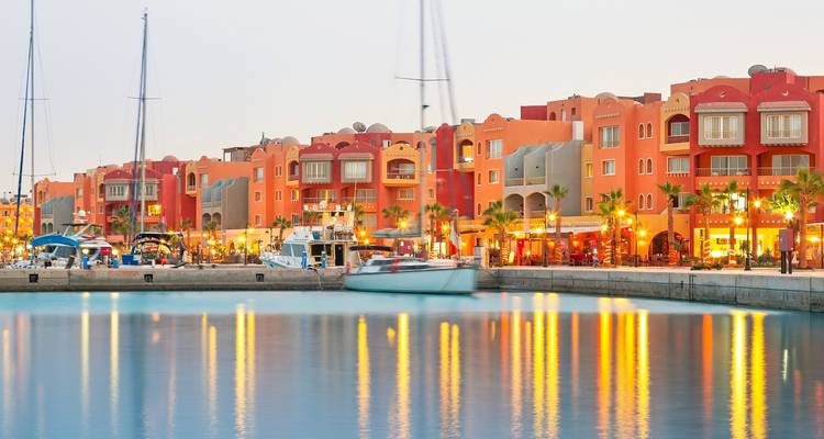 Kleurrijke gebouwen en boten bij een jachthaven.