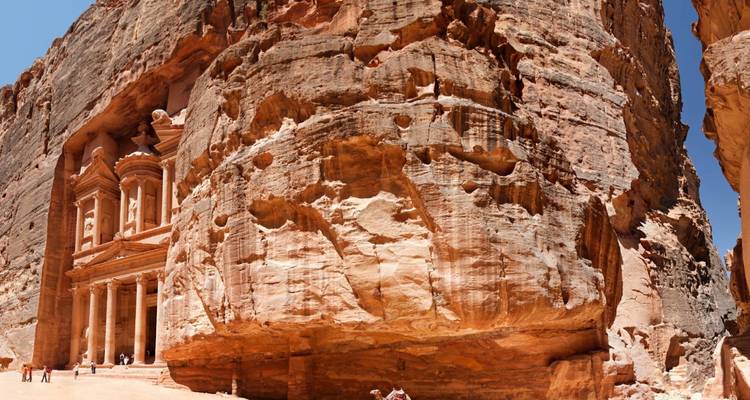 De iconische Schatkamer in Petra, een historische in de rots uitgehouwen architectuur met toeristen in de buurt.
