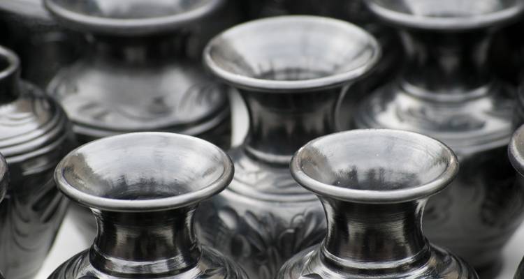 Close-up view of shiny black ceramic vases displayed in rows.