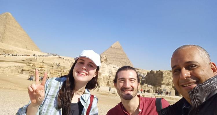Gruppe von Touristen, die ein Selfie mit den Pyramiden im Hintergrund macht.