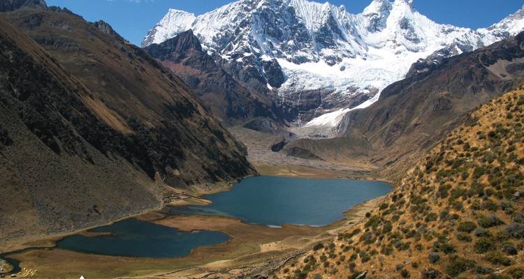 Lakes surrounded by mountains with snowy peaks in the background.