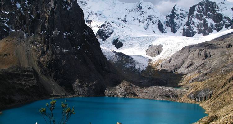 Body of water surrounded by rocky and snowy mountains.
