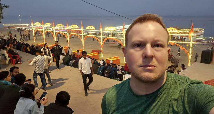 Selfie con un festival o evento junto al río de fondo.