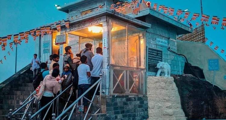 Menschen betreten ein mit Flaggen geschmücktes Gebäude mit einem steinernen Elefanten.