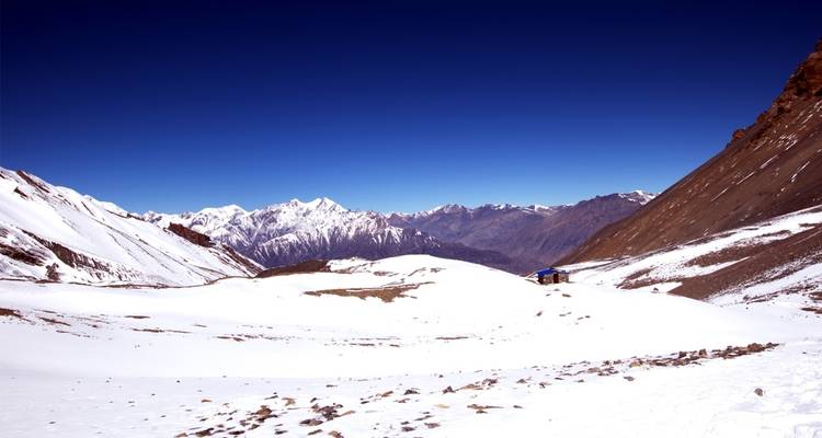 Snowy mountain landscape under clear blue sky.