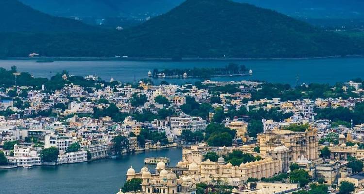 Blick auf eine Stadt mit einem See und umliegenden Hügeln.