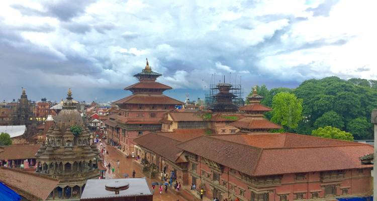 Bhaktapur Durbar Square with bustling activity and cloudy sky.
