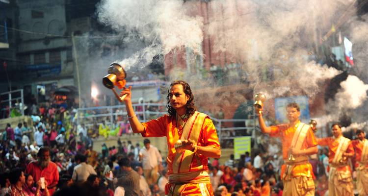 Abendzeremonie mit Menschen in traditioneller Kleidung und Rauch.
