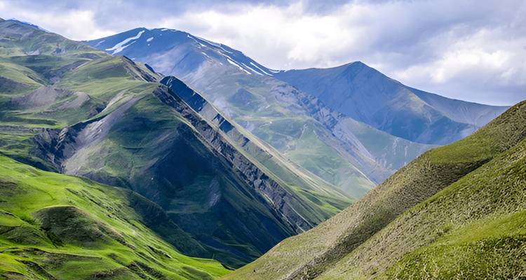 Paysage montagneux verdoyant aux pentes abruptes.