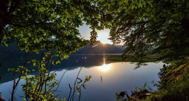 Lac serein avec coucher de soleil et reflet dans l'eau.