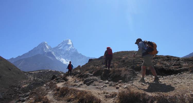 Wandelaars die richting besneeuwde bergen trekken.