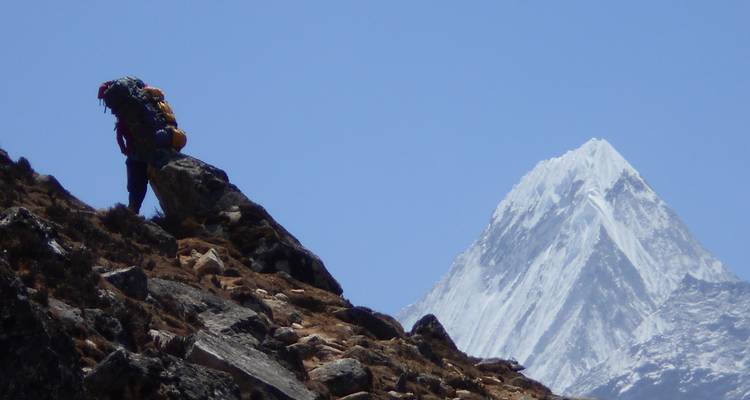 Wandelaar met een grote rugzak op een bergpad.