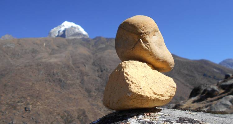 Stenen in balans met bergtop op de achtergrond.