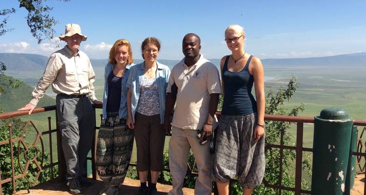 Gruppe von Touristen, die an einem Aussichtspunkt posieren und eine weite Landschaft überblicken.