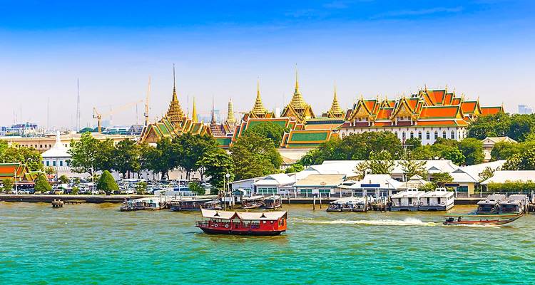 Vista del Gran Palacio al otro lado de un río con botes.