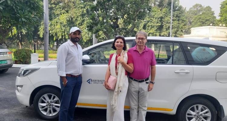 Couple de touristes avec un guide devant une voiture.