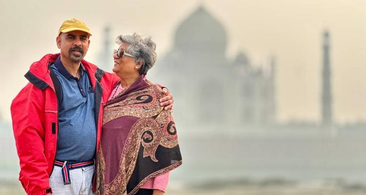 Couple posant avec le Taj Mahal en arrière-plan.