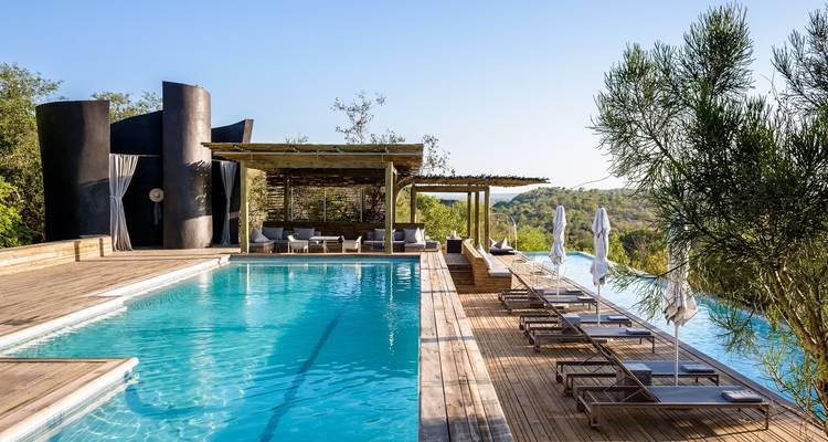 Luxe zwembad met ligstoelen en een schilderachtig uitzicht.