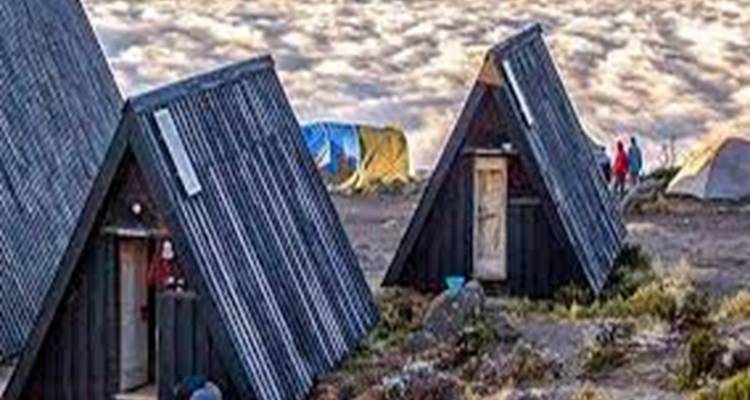 Small wooden huts with angled roofs surrounded by a rocky landscape.