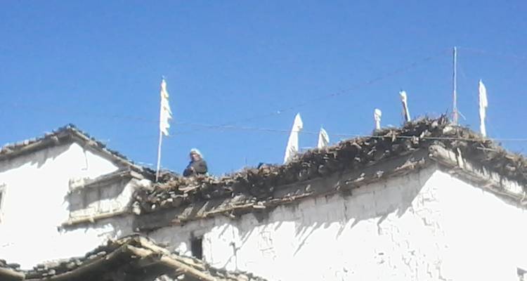 Person, die auf einem Dach mit wehenden Flaggen arbeitet.