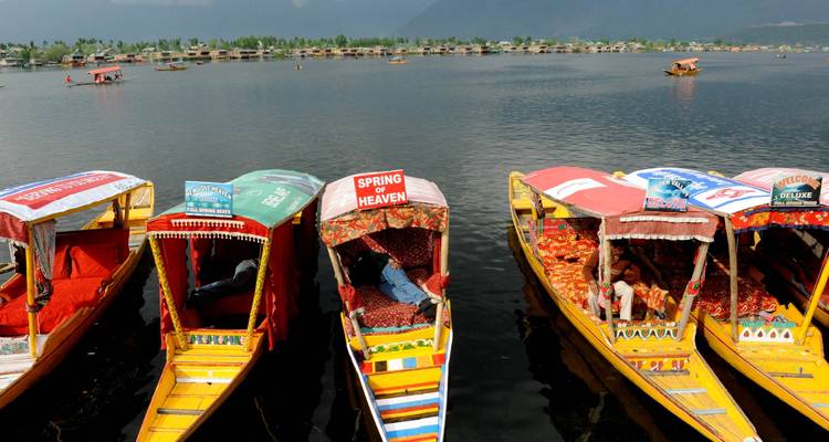 Des bateaux colorés sur un lac sous un ciel nuageux.