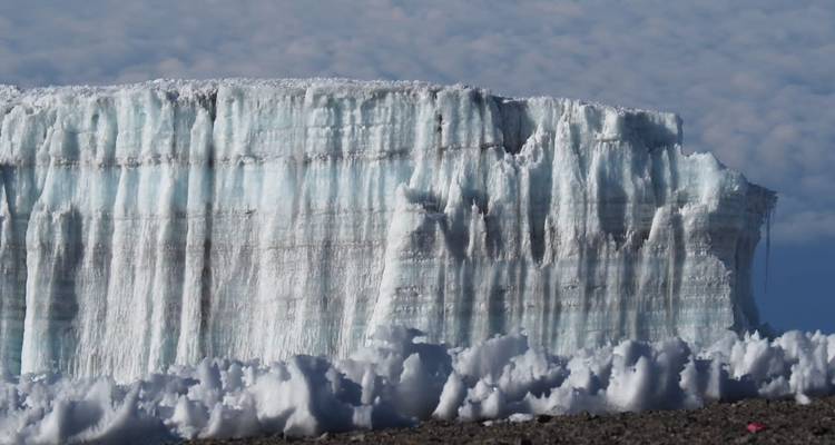 Nahaufnahme einer Eisklippe vor einem Wolkenhintergrund.
