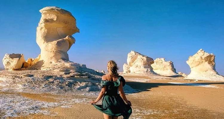 Frau, die auf weiße Felsformationen zugeht.