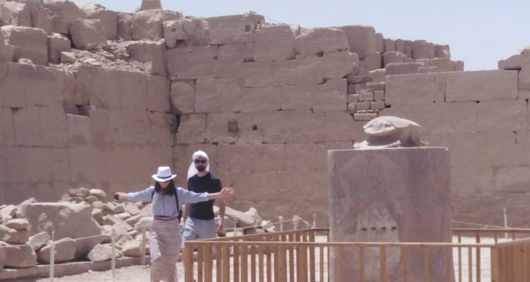 Paar posiert mit alter Steinstatue.