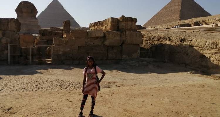 Frau posiert vor den Pyramiden und der Sphinx.