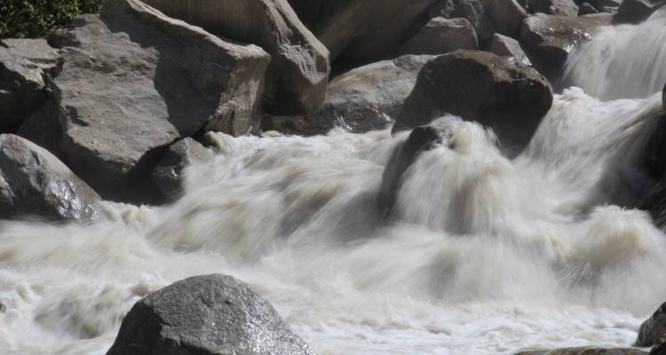 Stromend water valt in cascades over rotsen in een natuurlijke omgeving.