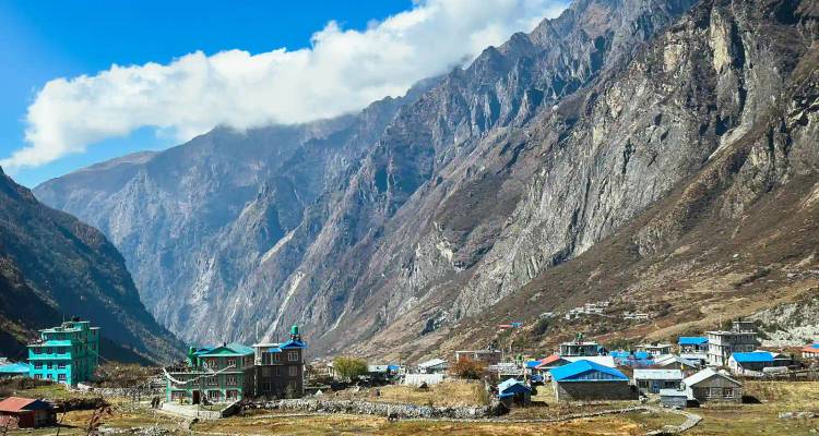 Afgelegen bergdorpje met kleurrijke daken verscholen onder torenhoge rotswanden in de Langtang Valley.