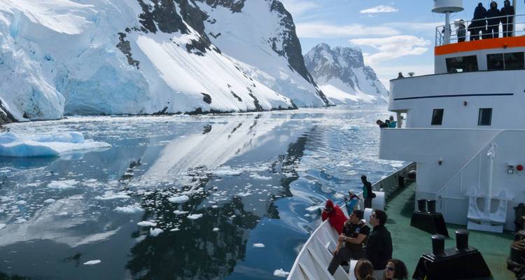 Crucero navegando por aguas heladas rodeado de montañas.