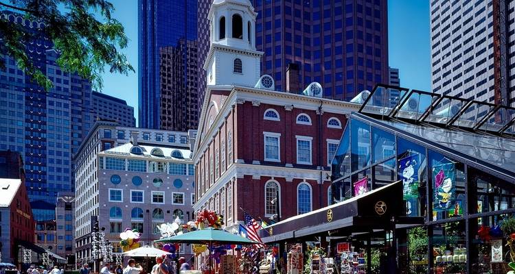 Bustling pedestrian market area with historic buildings in the background.
