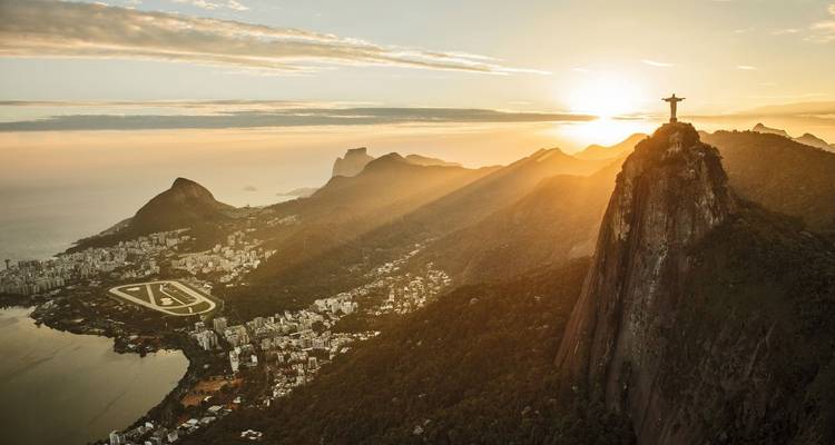 Lever de soleil spectaculaire sur Rio de Janeiro avec le Christ Rédempteur au sommet du Corcovado et des rayons de soleil balayant la ville et le littoral.