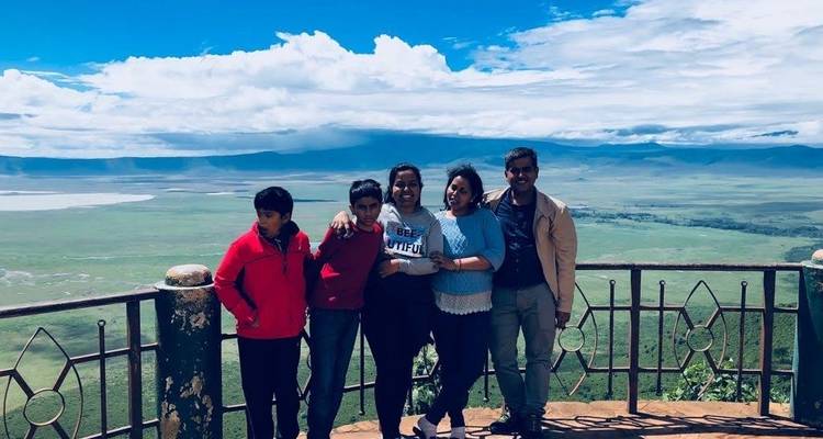 Groep mensen poserend voor een schilderachtig landschap met een hek.