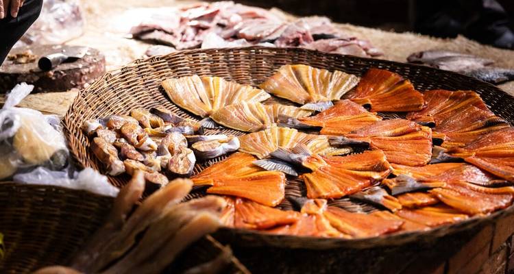 Un étal de marché avec une variété de fruits de mer séchés et frais.