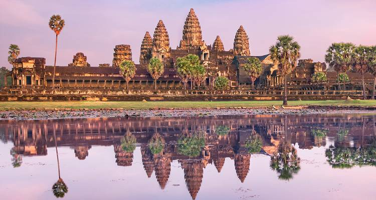 Complexe du temple d'Angkor Vat se reflétant dans l'eau au coucher du soleil.