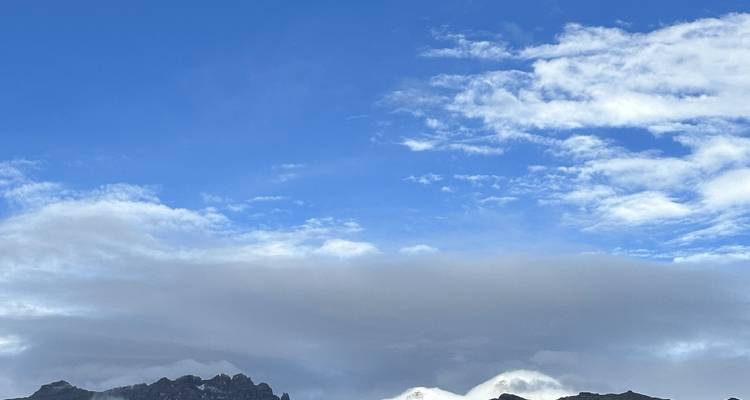 Vista del cielo con nubes y montañas.