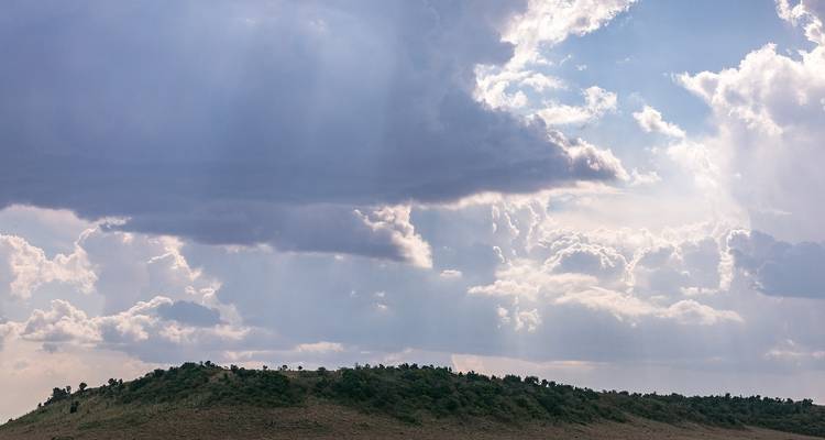 Paysage avec ciel nuageux au-dessus d'une colline.