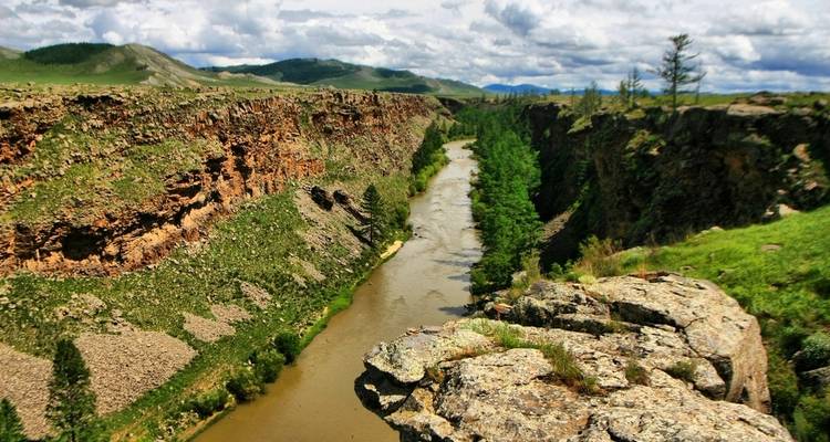 River flowing through a steep gorge with trees and greenery.