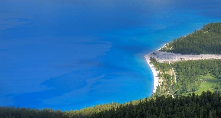 Lake with turquoise water and forested shoreline.