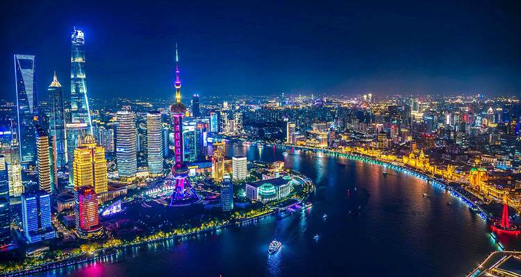 Espectáculo nocturno del horizonte de Pudong en Shanghái iluminado curvándose a lo largo del río Huangpu.