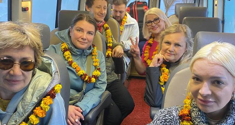 Des touristes à l'intérieur d'un bus, chacun portant une guirlande de soucis.