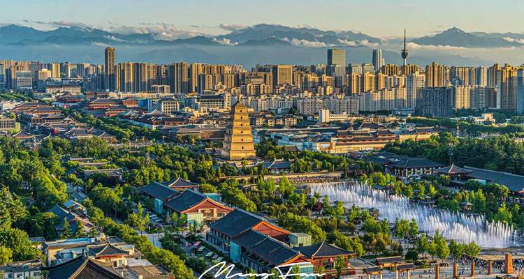 Panoramic skyline of Xi’an with the Giant Wild Goose Pagoda and fountains framed by distant mountains.