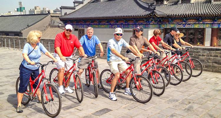 Groupe de touristes à vélo sur un site historique.