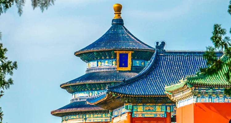 Les carreaux émaillés colorés et les avant-toits ornés du Temple du Ciel se détachent sur un ciel pâle.