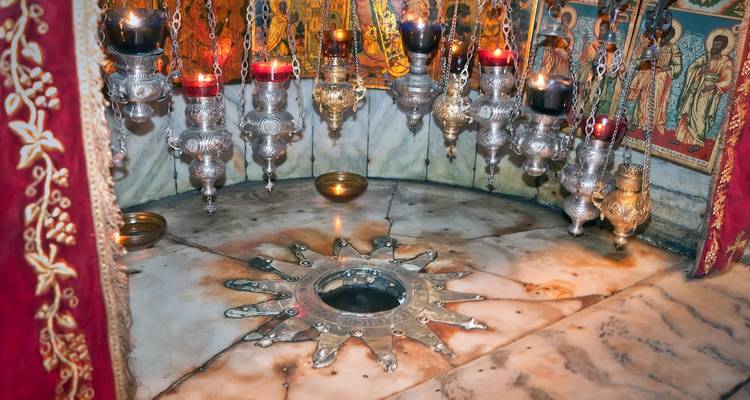 Interieur van een religieuze locatie met hangende lampen en sterembleem.