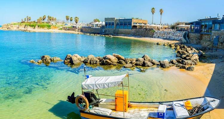 Klein bootje bij een kustdorp met helder water.