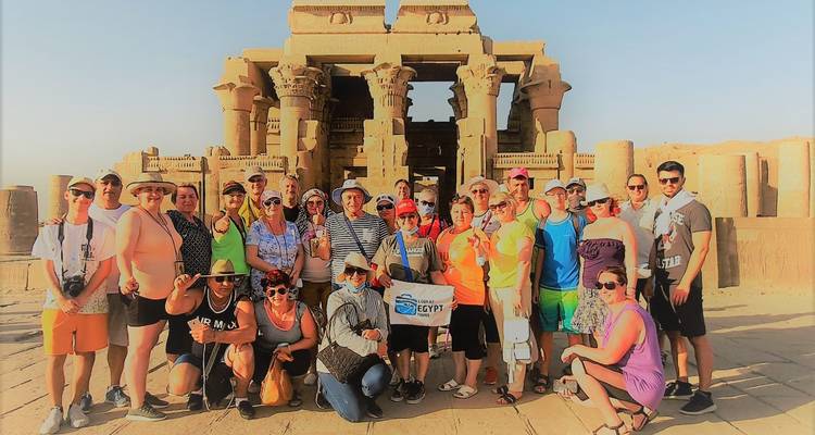 Group of tourists in front of an ancient Egyptian temple.