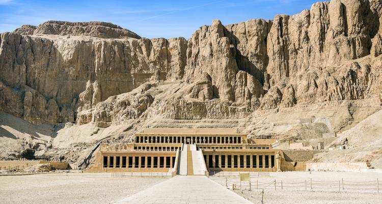 Templo construido en una pared rocosa con entrada de escalinata en Egipto.